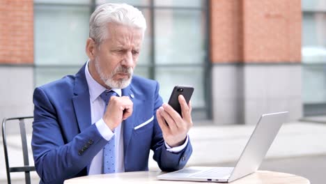 Viejo-empresario-molesto-por-la-pérdida-durante-el-uso-de-Smartphone