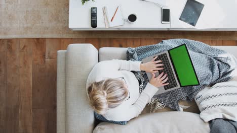 Overhead-Shot-Blick-nach-unten-auf-Frau-arbeiten-auf-Laptop-zu-Hause-liegend-auf-Sofa