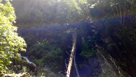 Schöne-frische-Wasserfall-unter-hohen-Felsen-witth-Grün-in-Sotschi,-Russland