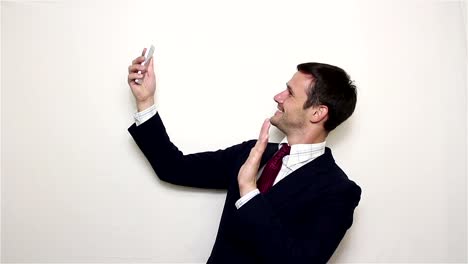 Young-handsome-businessman-making-selfie,-smiling-and-waving-his-hand.