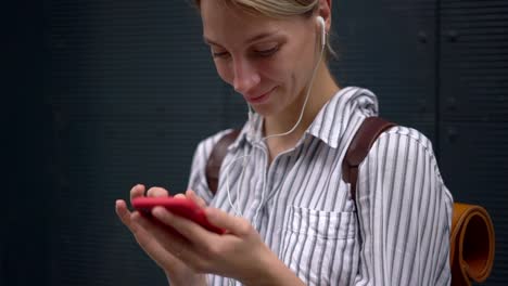 Slow-motion-effect-of-happy-meloman-enjoying-composition-in-playlist-via-modern-headphones-with-quality-sound-standing-outdoors