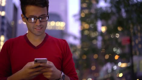 Guapo-hombre-en-gafas-disfrutando-de-la-comunicación-del-teléfono-inteligente-con-el-mejor-amigo-durante-el-tiempo-para-caminar-al-aire-libre