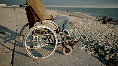 El-hombre-discapacitado-en-silla-de-ruedas-está-solo-con-el-mar