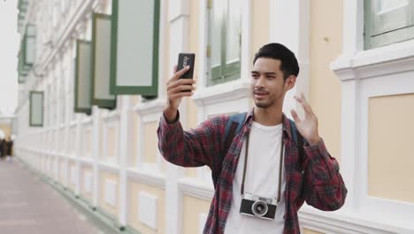 El-hombre-turístico-asiático-social-media-tomando-selfie-de-fotos-y-vlogger-video-en-vivo-en-línea-en-bangkok,-Tailandia,-viajes-en-solitario-y-concepto-de-mochilero