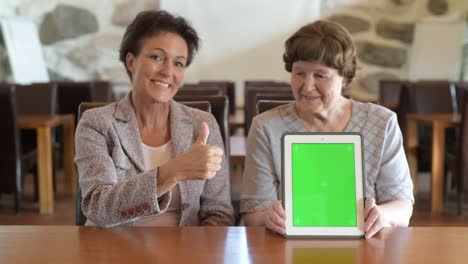 Happy-Mother-And-Daughter-Showing-Digital-Tablet-Together-And-Giving-Thumbs-Up