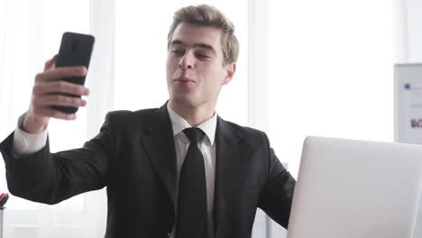 Businessman-having-fun-using-mobile-phone-at-office