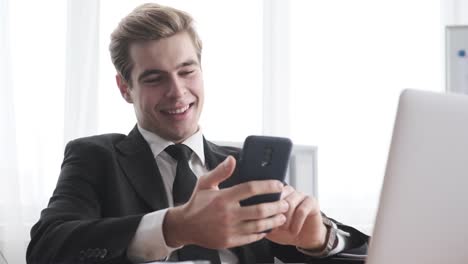 Geschäftsmann-mit-Handy-und-Selfie-im-Büro