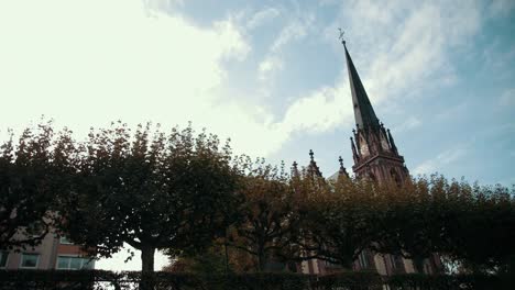 Old-Church-in-Gothic-style.-With-pointed-roof-and-clock.-In-foreground-is-trees