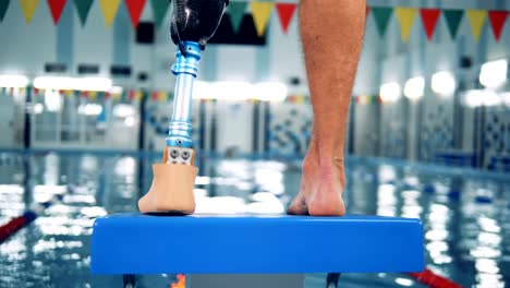 Swimming-pool-and-a-male-with-a-robotic-leg-standing.