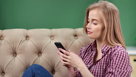 Pensive-female-typing-message-using-telephone-resting-at-home.-Medium-close-up-shot-on-4k-RED-camera