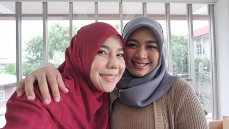 Attractive-two-muslim-business-woman-Take-a-picture-of-yourself,-Selfie-or-videocall-with-Smart-phone