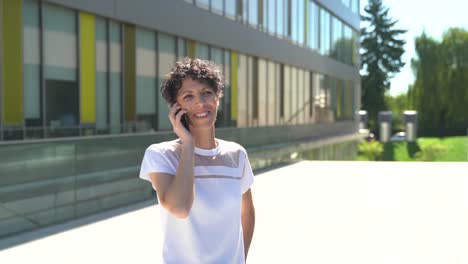 Zoom-in-close-up-shot-of-confident-mature-female-entrepreneur-talking-on-mobile-phone-outside-office-building