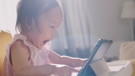 Excited-Asian-Baby-Girl-Watching-Cartoon-on-Tablet