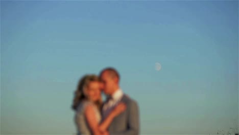 Hombre-y-mujer-borrosa-stand-abrazando-a-la-luna-en-el-fondo-del-cielo.-Pareja-silueta-beso-en-brillante-disco-lunar-brillando-en-el-espacio-de-cielo-claro.-Planificación-fase-lunar-de-embarazo-ciclos-de-fertilidad