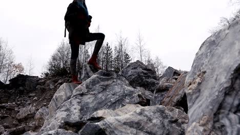 Retrato-de-una-muchacha-en-las-rocas-contra-las-piedras-del-fondo.-Ropa-de-otoño.-Paisaje,-gran-angular