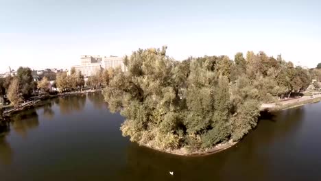 Aerial-view-of-Central-Moscow-Gorky-park.-Crowds-of-people-walking-over-central-park-in-Moscow,-Russia.-Moscow-river-bank,-park-full-of-green-trees-on-a-sunny-spring-day.