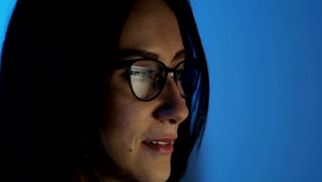 Business-woman-in-glasses-works-at-the-computer-at-the-office-in-the-night.