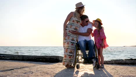 Dad,-Child-And-mother-hugging-each-other-joyful-family-on-background-sea