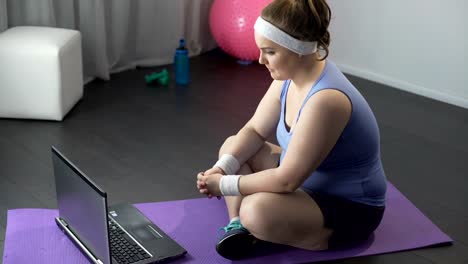 Chica-gorda-viendo-videos-en-línea-con-los-métodos-de-entrenamiento-famoso-en-su-portátil