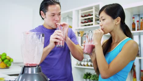 Young-Ethnic-couple-using-blender-organic-fruit-drink