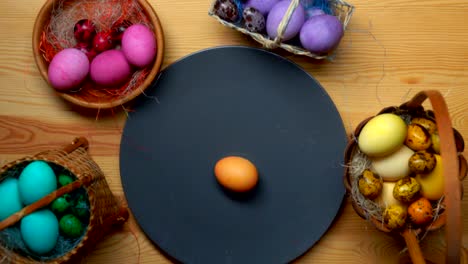 Child's-hand-lays-colored-easter-eggs-in-different-baskets