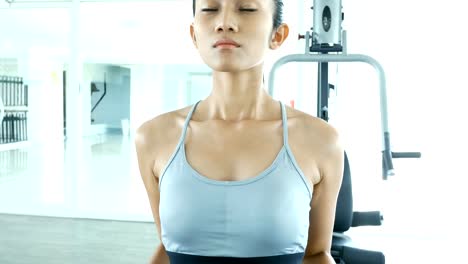 Sporty-young-asian-woman-exercising-with-dumbbells-in-the-gym.-Woman-exercise-at-fitness-gym.-Sport-and-Reaction-concept.-4k-Resolution.