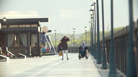 Mujer-joven-con-hombre-discapacitado-en-silla-de-ruedas-pasar-tiempo-juntos-en-el-muelle