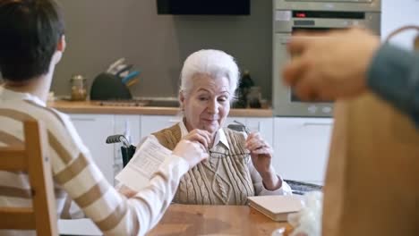 Young-Woman-Helping-Elderly-Lady-with-Bills