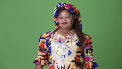 Overweight-beautiful-African-woman-wearing-traditional-clothing-against-green-background