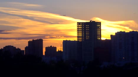 vistas-de-la-ciudad-al-atardecer-con-un-avión-volando-en-el-horizonte