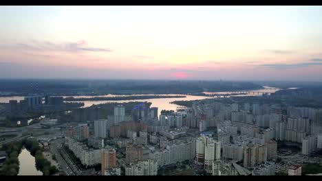 Aerial-panoramic-video-from-the-drone-to-the-Darnyts'kyi-district,-river-Dnieper-with-bridges-in-city-Kiev,-Ukraine-and-the-right-bank-of-Dnieper-at-sunset-in-the-summer.-FullHD-video.