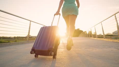 LOW-ANGLE:-Young-woman-in-heels-runs-with-her-luggage-to-reach-airport-on-time.