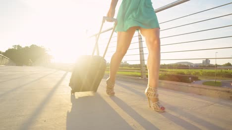 CLOSE-UP:-Gorgeous-woman-in-heels-walks-across-an-overpass-with-a-suitcase.