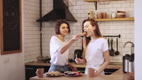 Two-funny-young-lesbians-eat-sushi-rolls-at-home.