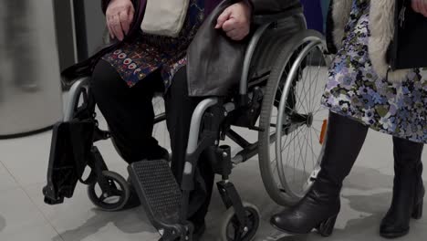 Wheelchair-service-in-airport-terminal,-disabled-person-sitting-in-wheelchair