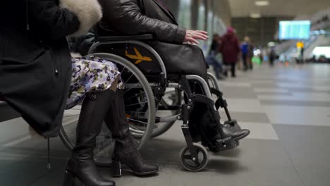 Servicio-de-silla-de-ruedas-en-la-terminal-del-aeropuerto,-discapacitado-sentado-en-silla-de-ruedas