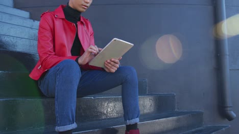 Transgender-adult-using-a-digital-tablet-in-the-street