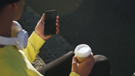 Transgender-adult--with-coffee-using-a-phone