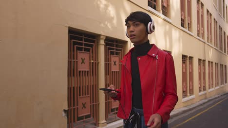 Transgender-adult-listening-to-music-in-the-street