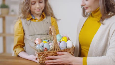 Mujer-feliz-y-chica-posando-con-huevos-de-Pascua