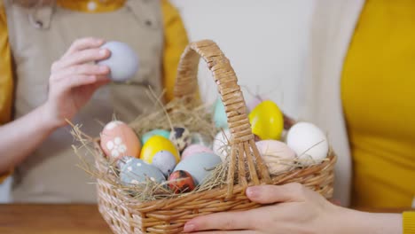 Irreconocible-niña-y-mujer-sosteniendo-cesta-de-huevos-de-Pascua