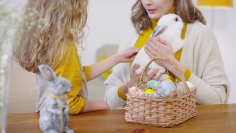 Mujer-y-niña-Petting-Bunny-en-Pascua