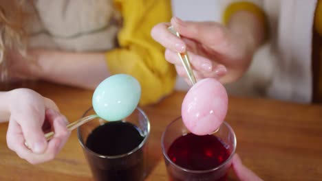 Hands-Holding-Dyed-Easter-Eggs-on-Spoons