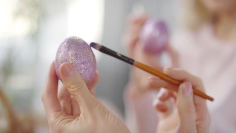 Unkenntlich-erkennbare-Frau-setzt-Glitter-auf-Ostereier