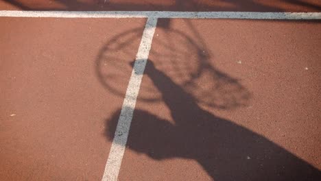 Nahaufnahme-Porträt-des-Schattens-von-jungen-attraktiven-männlichen-Basketballspieler-mit-einem-Reifen-im-Freien-auf-dem-Platz