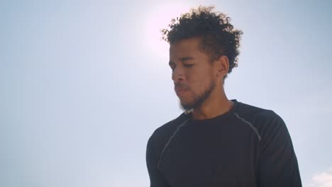 Retrato-de-primer-plano-del-joven-jugador-de-baloncesto-masculino-afroamericano-atlético-lanzando-una-pelota-en-un-aro-al-aire-libre