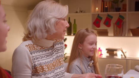 Abuela-con-nietas-cena-de-Navidad-alegría-regalos-alegría-felicidad-sonrisa