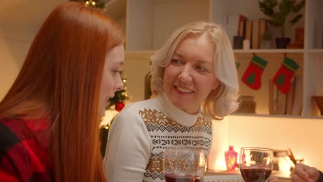 La-nieta-adolescente-de-jengibre-habla-con-la-abuela-en-Navidad.-Cena-familiar.