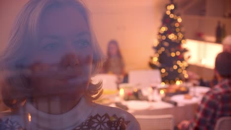 Sad-grandmother-looks-out-the-window-Christmas-dinner-family-behind-glass