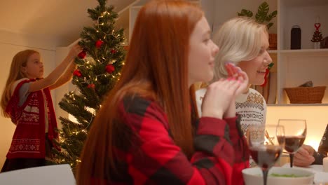 Little-blond-girl-decorates-Christmas-tree-Family-dinner-Gifts-Holiday-ginger-teen